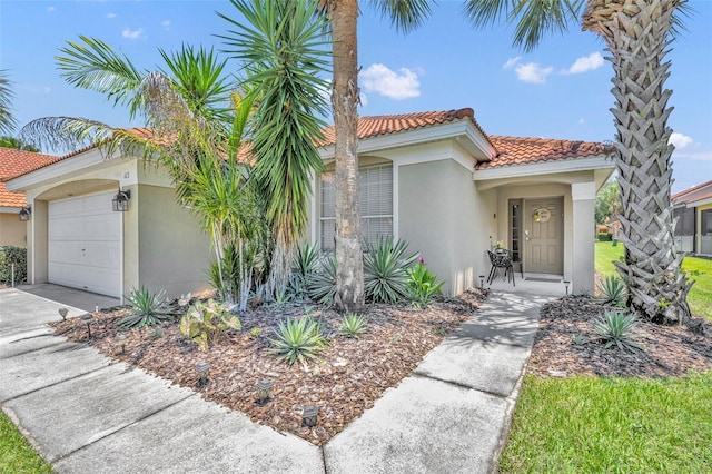 mediterranean / spanish-style home featuring stucco siding, a tile roof, driveway, and a garage