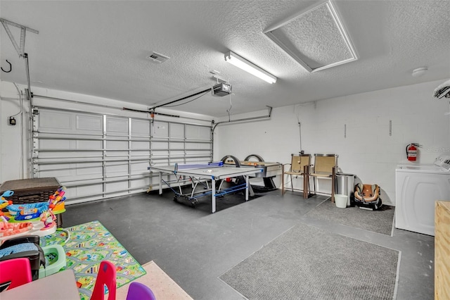 garage with washer / clothes dryer and a garage door opener