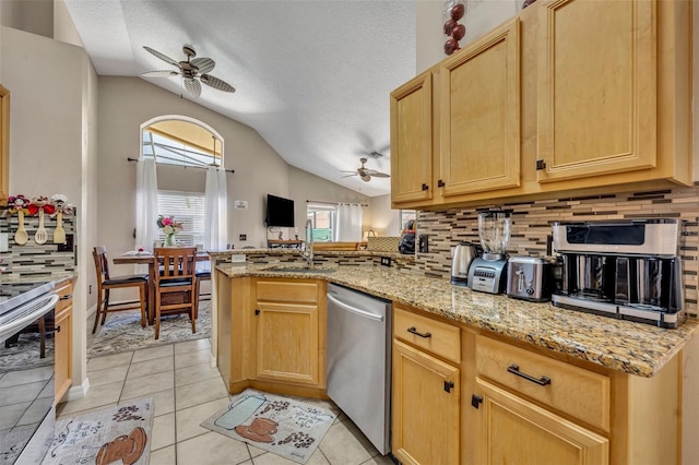 kitchen featuring ceiling fan, stainless steel dishwasher, lofted ceiling, decorative backsplash, and a textured ceiling
