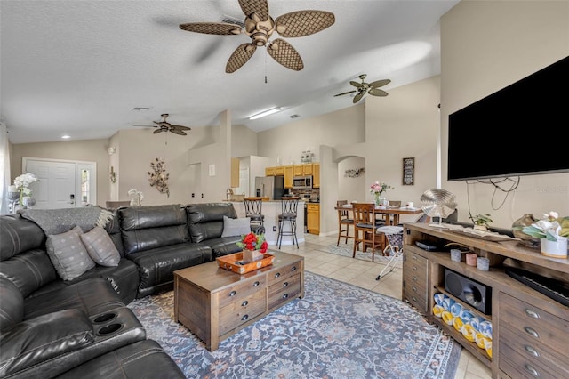 living area featuring ceiling fan, lofted ceiling, and light tile patterned flooring
