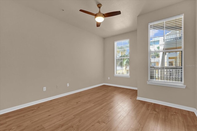 empty room with baseboards, a ceiling fan, and wood finished floors