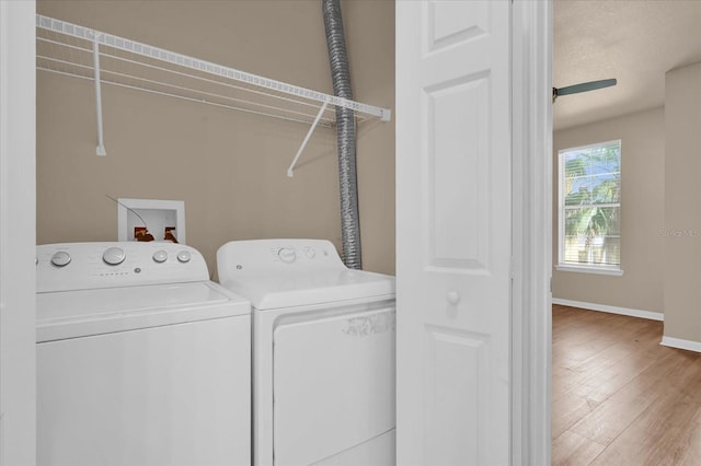 laundry area with independent washer and dryer, wood finished floors, and baseboards