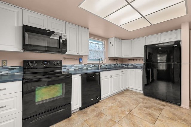 11811 Scarecrow Ln, Orlando, FL 32821 - kitchen featuring black appliances, a sink, dark countertops, and white cabinetry
