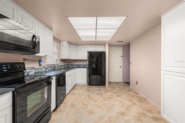 11811 Scarecrow Ln, Orlando, FL 32821 - kitchen featuring black appliances, dark countertops, a sink, white cabinets, and baseboards