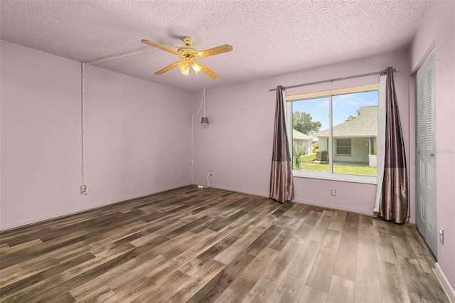 11811 Scarecrow Ln, Orlando, FL 32821 - empty room featuring wood finished floors, a textured ceiling, ceiling fan, and baseboards