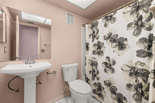 11811 Scarecrow Ln, Orlando, FL 32821 - full bath featuring toilet, tile patterned flooring, a shower with shower curtain, and a sink