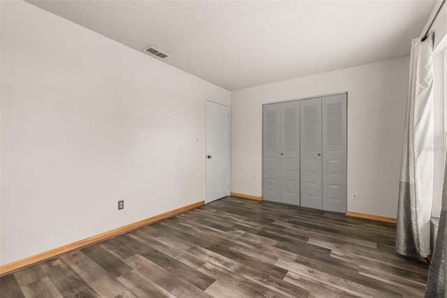 11811 Scarecrow Ln, Orlando, FL 32821 - unfurnished bedroom with wood finished floors, baseboards, and a closet