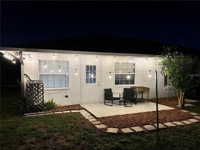 11811 Scarecrow Ln, Orlando, FL 32821 - back of house at night with a patio and stucco siding