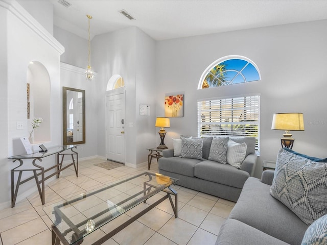2115 Morning Star Dr, Clermont, FL 34714 - tiled living room with a towering ceiling, arched walkways, and baseboards