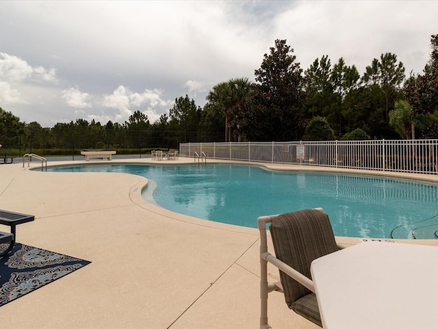 2115 Morning Star Dr, Clermont, FL 34714 - community pool featuring a patio and view of wooded area