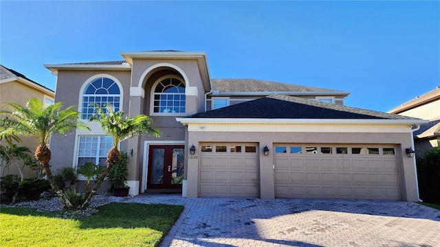 12126 Diedra Ct, Orlando, FL 32825 - traditional-style house with french doors, a garage, decorative driveway, and stucco siding