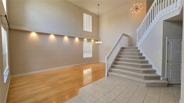 12126 Diedra Ct, Orlando, FL 32825 - stairway featuring a chandelier, a towering ceiling, wood finished floors, and baseboards