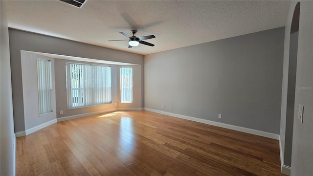 12126 Diedra Ct, Orlando, FL 32825 - empty room with ceiling fan, wood finished floors, baseboards, and a textured ceiling