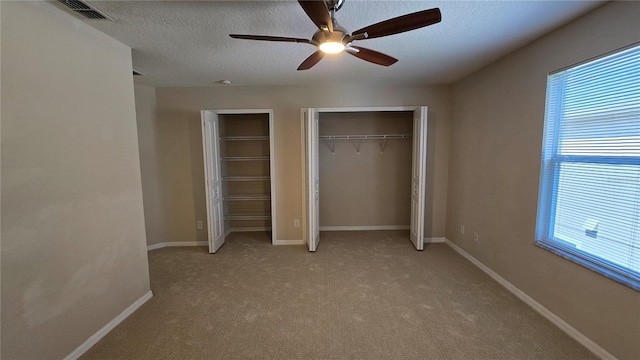 12126 Diedra Ct, Orlando, FL 32825 - unfurnished bedroom with multiple closets, multiple windows, light carpet, and a textured ceiling