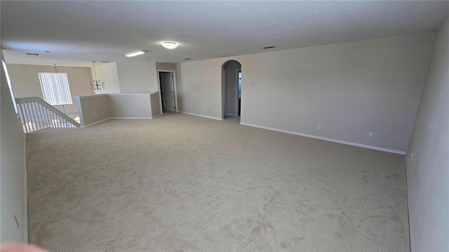 12126 Diedra Ct, Orlando, FL 32825 - empty room featuring arched walkways, light carpet, and baseboards