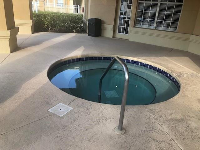 view of swimming pool with a hot tub and a patio area