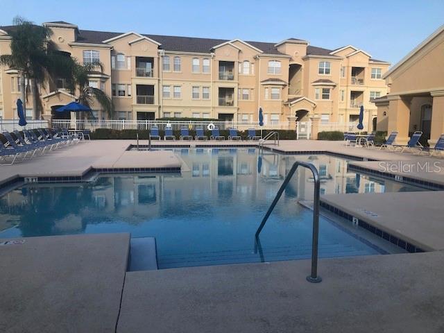 community pool featuring fence and a patio