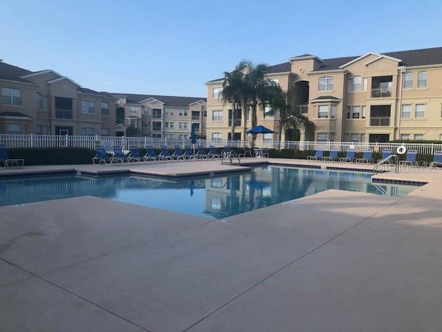 community pool with fence and a patio area