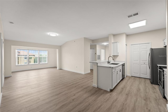 5447 Vineland Rd Unit 1308, Orlando, FL 32811 - kitchen featuring a sink, light wood-style floors, open floor plan, appliances with stainless steel finishes, and light countertops