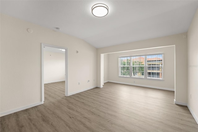 5447 Vineland Rd Unit 1308, Orlando, FL 32811 - unfurnished room featuring light wood-type flooring, baseboards, a smoke detector, and lofted ceiling