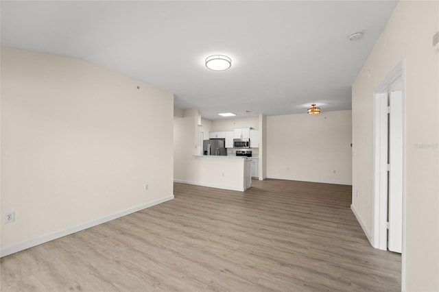 5447 Vineland Rd Unit 1308, Orlando, FL 32811 - unfurnished living room featuring light wood-style floors and baseboards
