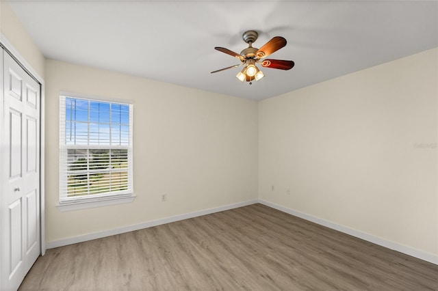 5447 Vineland Rd Unit 1308, Orlando, FL 32811 - unfurnished bedroom with light wood-style flooring, a closet, baseboards, and ceiling fan