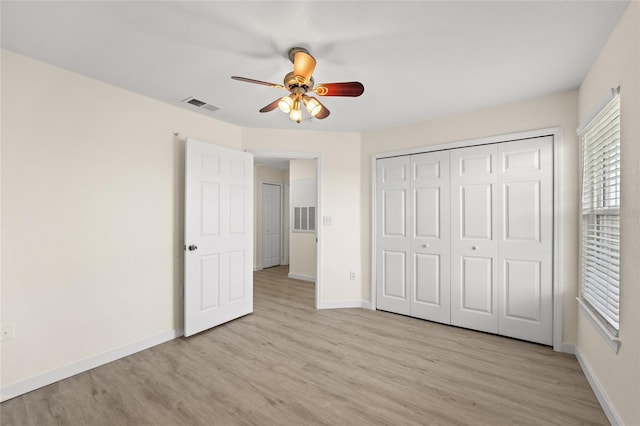 5447 Vineland Rd Unit 1308, Orlando, FL 32811 - unfurnished bedroom featuring light wood-type flooring, baseboards, and a closet
