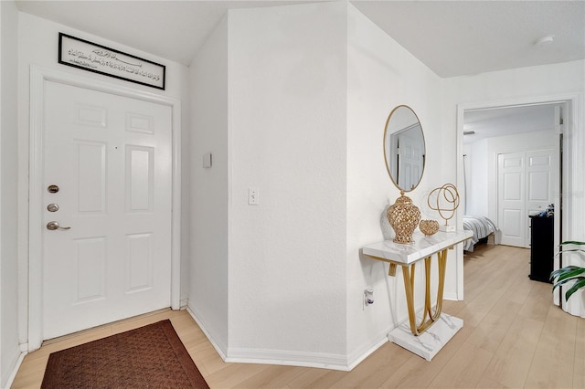 foyer entrance featuring light wood-style floors and baseboards
