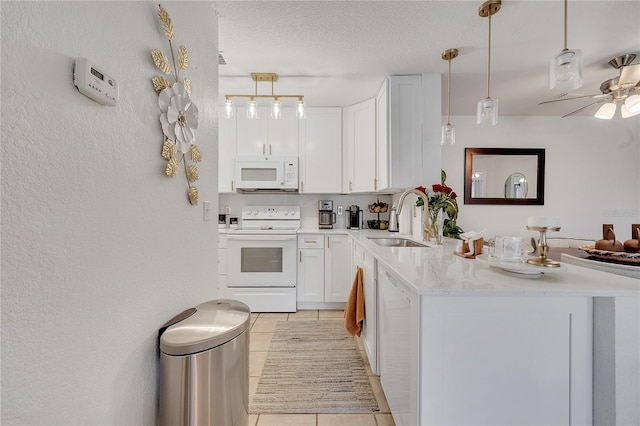 kitchen with white appliances, a sink, a peninsula, light tile patterned flooring, and a ceiling fan