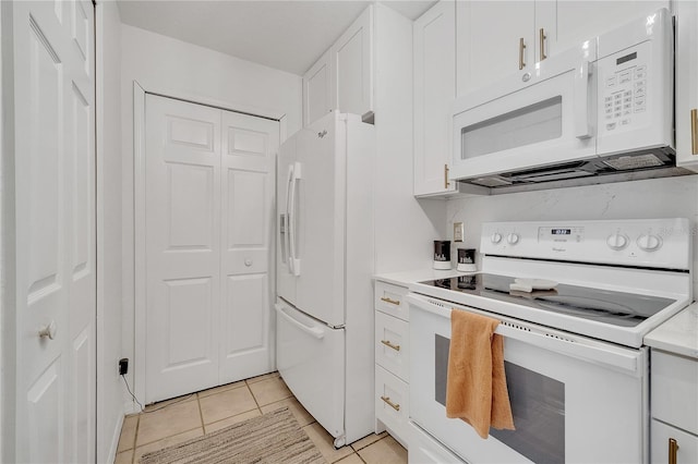 kitchen with white appliances, white cabinets, light tile patterned flooring, and light countertops