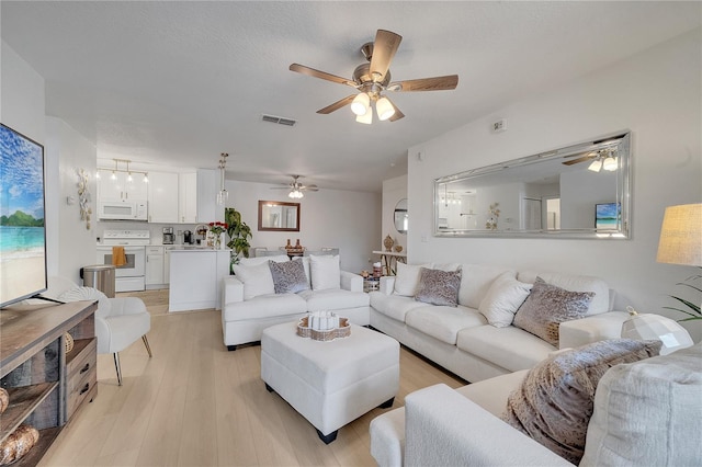 living room featuring ceiling fan and light wood-style floors