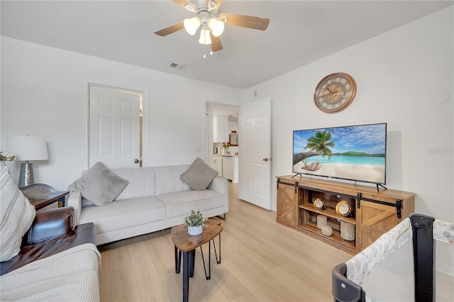 living room with light wood finished floors and ceiling fan