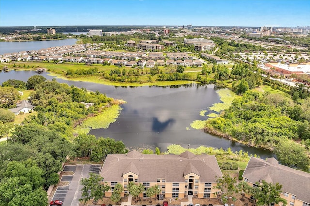 drone / aerial view of a nearby body of water and a tree filled landscape