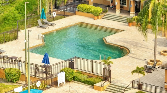 community pool featuring a patio area and fence