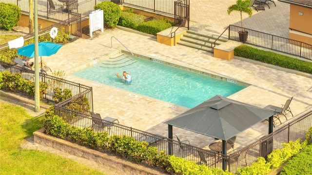 community pool with a patio and fence