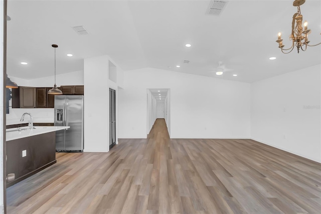 1050 20th St, Orlando, FL 32805 - kitchen with stainless steel fridge, open floor plan, light countertops, dark brown cabinetry, and lofted ceiling