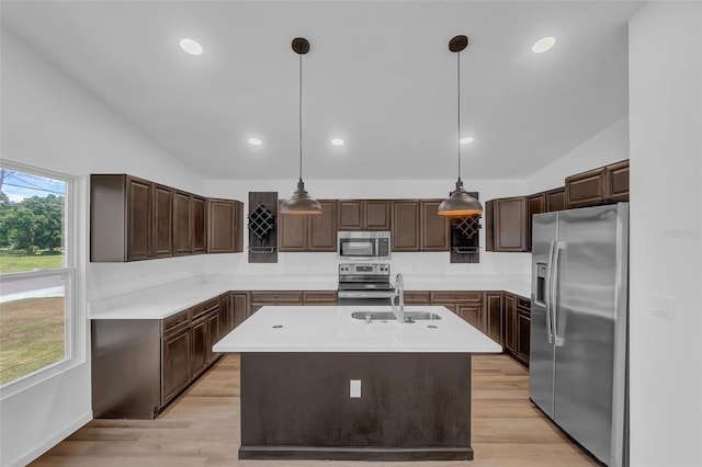 1050 20th St, Orlando, FL 32805 - kitchen with stainless steel appliances, a sink, light countertops, a center island with sink, and light wood-type flooring