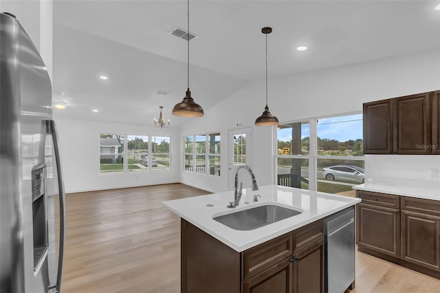 1050 20th St, Orlando, FL 32805 - kitchen featuring stainless steel appliances, a sink, light countertops, light wood-style floors, and lofted ceiling
