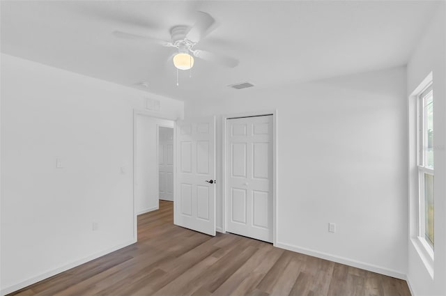 1050 20th St, Orlando, FL 32805 - unfurnished bedroom featuring wood finished floors, baseboards, a ceiling fan, and a closet