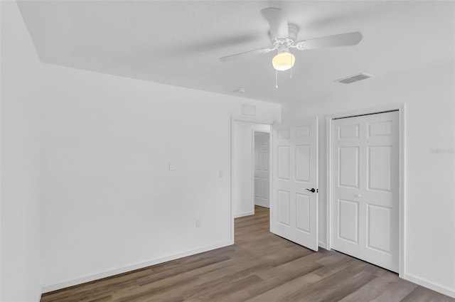1050 20th St, Orlando, FL 32805 - unfurnished bedroom featuring wood finished floors, baseboards, a ceiling fan, and a closet