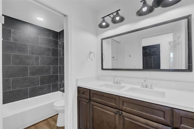 1050 20th St, Orlando, FL 32805 - full bathroom featuring toilet, double vanity, shower / bath combination, and wood finished floors