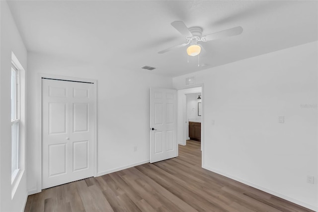 1050 20th St, Orlando, FL 32805 - unfurnished bedroom featuring wood finished floors, a closet, baseboards, and a ceiling fan