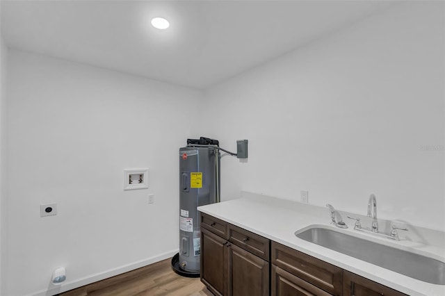 1050 20th St, Orlando, FL 32805 - laundry room with hookup for an electric dryer, water heater, hookup for a washing machine, cabinet space, and light wood finished floors