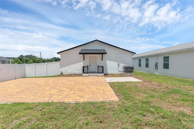 1050 20th St, Orlando, FL 32805 - back of property featuring central air condition unit, a patio, and stucco siding