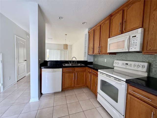 kitchen featuring white appliances, a sink, brown cabinets, light tile patterned floors, and backsplash