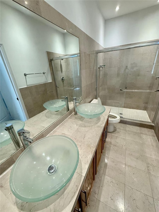 bathroom with a stall shower, toilet, double vanity, and recessed lighting
