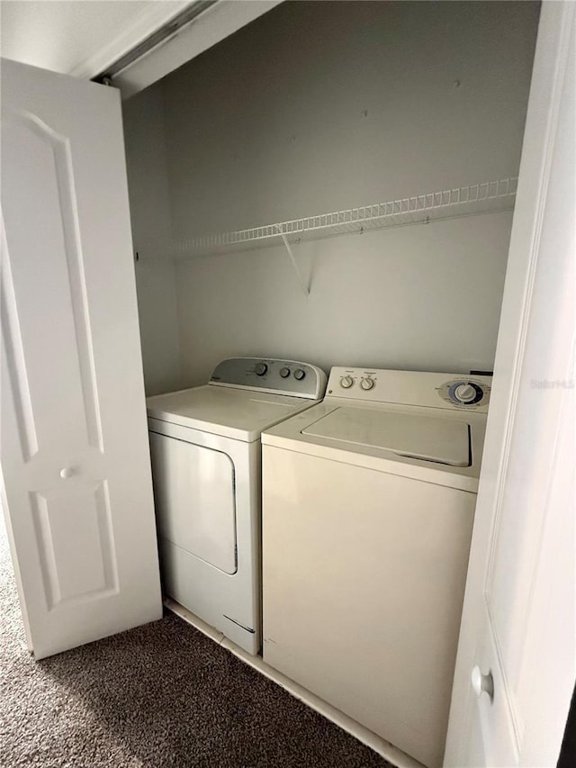 washroom featuring washer and clothes dryer and dark carpet