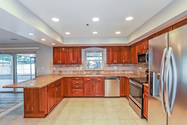 2006 Sycamore Ln, Plant City, FL 33563 - kitchen featuring stainless steel appliances, a peninsula, light stone countertops, backsplash, and healthy amount of natural light