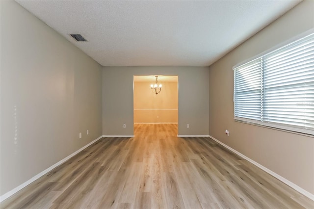 2006 Sycamore Ln, Plant City, FL 33563 - unfurnished room with a chandelier, light wood-style floors, baseboards, and a textured ceiling
