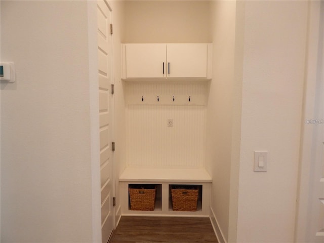 mudroom with dark wood finished floors and baseboards